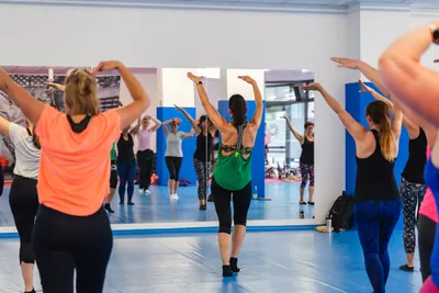 Fitnesskurs beim Aufwärmen vor der Spiegelwand